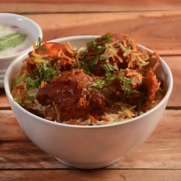 Aachi Biryani's chicken biryani, topped with fresh cilantro, served in a white bowl on a wooden table.