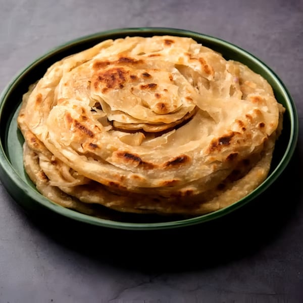 Aachi Biryani's flaky, golden-brown Indian parotta bread, served in a green bowl.